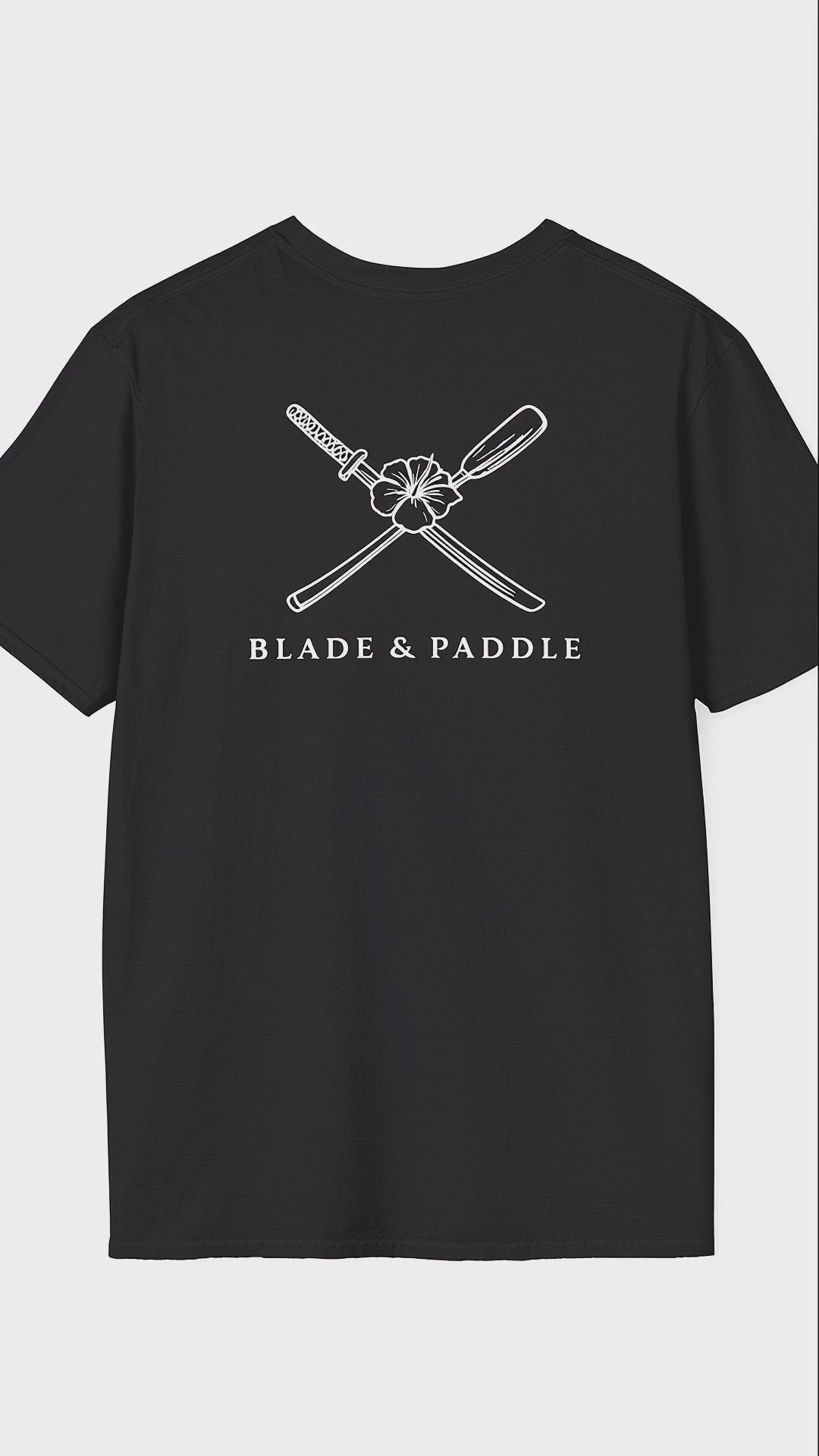 suspended black t-shirt, rotating showing large white lineart graphic of a katana blade/kayak crossed with the Hawaii state flower, the hibiscus, in the center on the shirt back, and a smaller version of the same logo over the heart on the front of the same shirt.