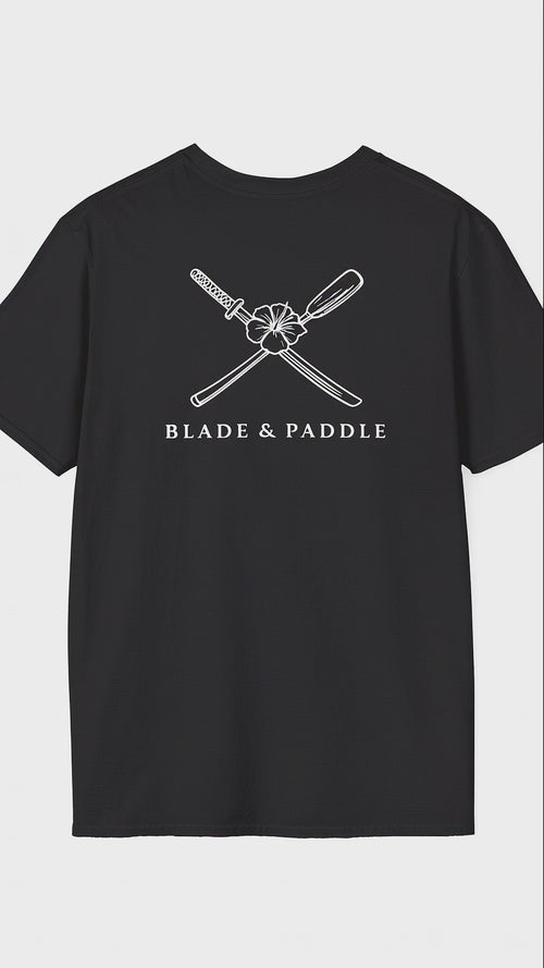 suspended black t-shirt, rotating showing large white lineart graphic of a katana blade/kayak crossed with the Hawaii state flower, the hibiscus, in the center on the shirt back, and a smaller version of the same logo over the heart on the front of the same shirt.